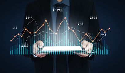 Businessman in formal attire presents a tablet displaying dynamic digital graphs. Ideal visual for concepts related to financial analysis and market trends. Scalp