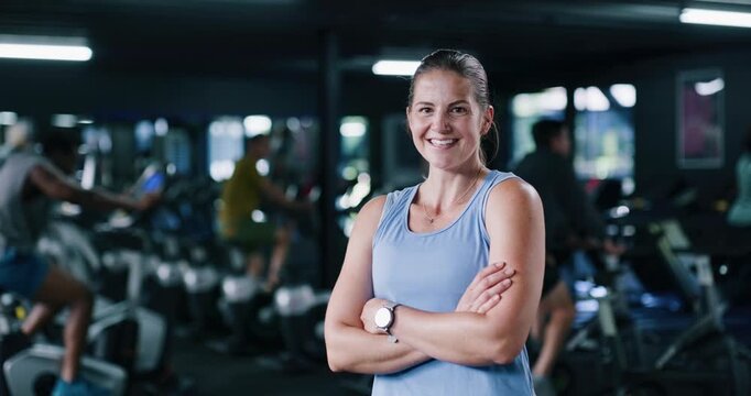 Face, fitness and happy woman in gym with arms crossed, confidence and spin class instructor. Portrait, smile and indoor cycling coach in health club for exercise, professional trainer and pride