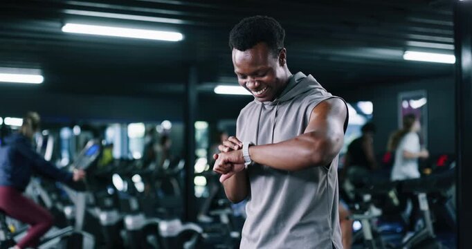 Smart watch, training or man in gym, fist pump or workout with digital app to track progress. Athlete, celebration or person in health center, target or achievement with fitness and exercise goals - Powered by Adobe