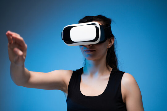 Woman using VR headset with outstretched arm inside immersive virtual reality digital environment