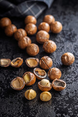 Tasty macadamia nuts on black table.