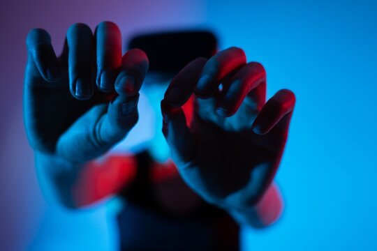Close-up of hands reaching toward a virtual interface while the user wears a VR headset