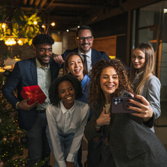 Diverse business colleagues celebrating christmas party taking selfie