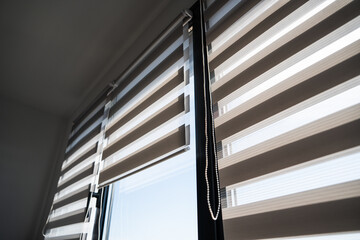 Obraz premium Stylish zebra blinds and sunlight reflections in bright modern living space