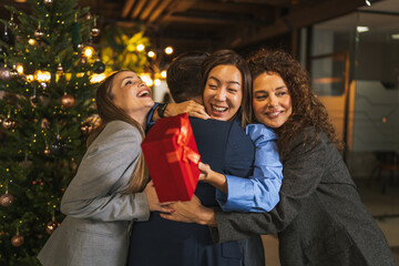 Diverse colleagues celebrating exchanging gifts at office christmas party