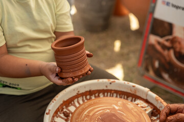 Child's Hands Learning Pottery on a Wheel with an Adult Instructor, Intergenerational Craft