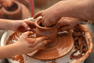 Child's Hands Learning Pottery on a Wheel with an Adult Instructor, Intergenerational Craft