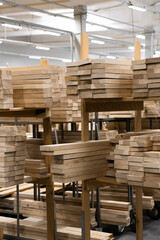 Stacked lumber fills a warehouse, neatly organized on pallets. Concept of resourcefulness, sustainable forestry, or raw materials for construction.