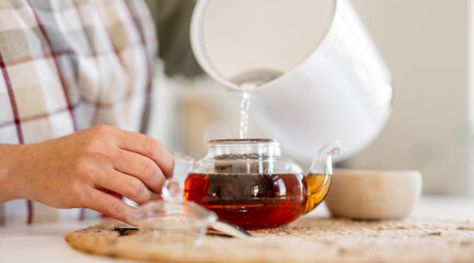 Woman Pouring Tea Into Mug
