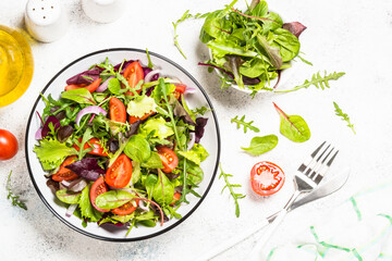 Green salad with fresh vegetables at white.