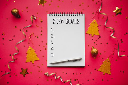 2026 goals list with festive decorations on blue background. Creative New Year planning and resolution concept with copy space for motivational or holiday-themed projects.