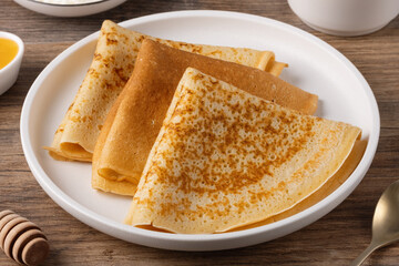 Traditional Russian pancakes with honey on a wooden table. Homemade russian thin pancakes blini. Russian food, russian kitchen