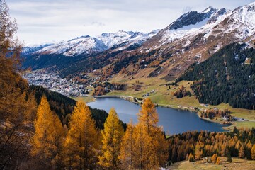 Autumnal mountain panorama in Davos with a view of the lake. Majestic Mountain Landscape, Scenic Valley With Colorful Ridges And Peaks, Serene Mountain Vista With Snowcovered Summits Vibrant Meadows