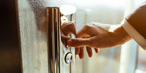 Close-up. A human finger presses an elevator button. A man's hand indoors. A red button. Concept of technology.