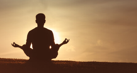 Silhouette of Person Meditating in Nature at Sunset