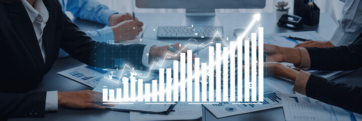 A professional business team collaborates in a modern office environment, analyzing data trends and discussing strategies for growth and success. Axiom
