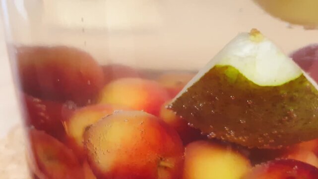 Footage of floating fruits in a glass jar, Compote