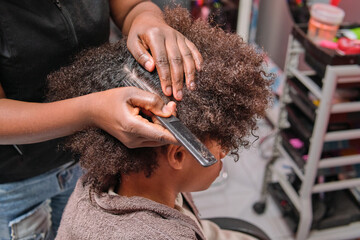 Hairstylist sectioning afro hair from above for African braids
