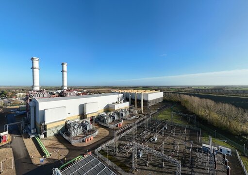 Aerial view of the power plant with tall white chimneys contrasting against the clear blue sky, Centenary Way, Spalding, England, United Kingdom.