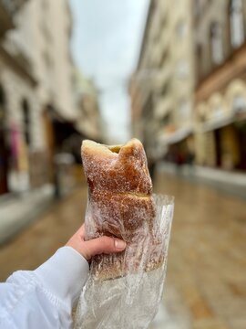 Hand holding kurtoskalacs chimney cake in budapest street