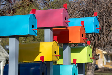 A group of colorful birdhouses made from mail boxes.