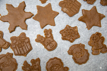 Christmas gingerbread cookies before baking on parchment paper