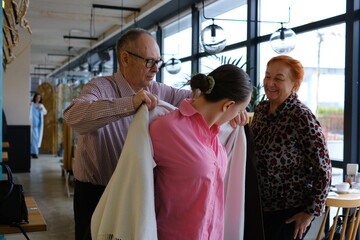 Grandfather, grandmother and granddaughter walking down the street, teenage girl in a brown coat, bald man and woman with red hair. High quality photo