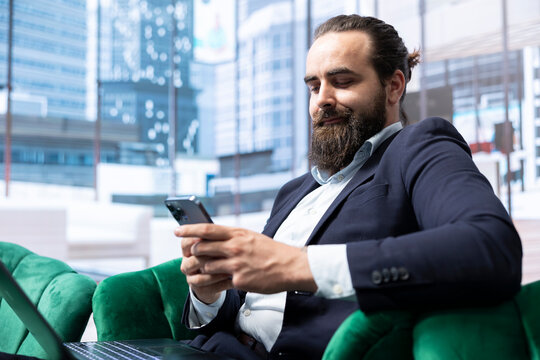 Determined chief executive officer analyzing stock market trends, browsing the web on his smartphone and ensuring company efficiency. Builds a growing business empire at the office.