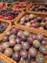 Passion fruits or maracuya and grapes on supermarket shelves
