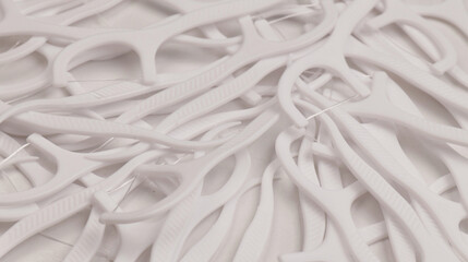 White dental floss picks scattered in pile, top view. Plastic flossers for oral hygiene and daily dental care. Modern dental tool for cleaning between teeth. Dental floss pick concept for health care.