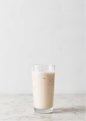 Classic winter eggnog in tall glass on clean white studio background with neutral styling and copy space for beverage advertising