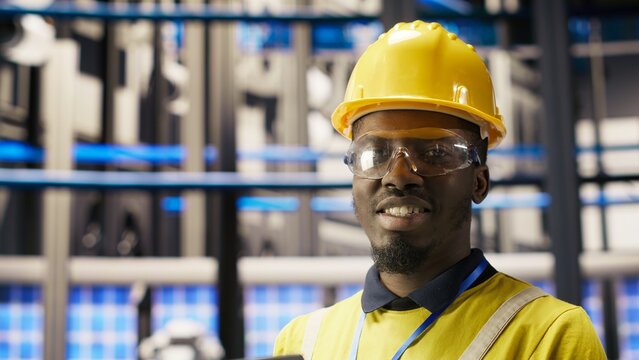 Professional working in smart factory, testing automated systems to ensure reliability. African american man in industry 4.0 plant using notebook to identify bottlenecks and optimize, camera B