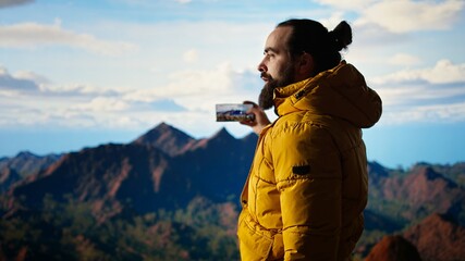 Hiker adventure seeker captures the breathtaking scenic view at the top of mountain, gazes at a distant mountain range and embraces beauty of the wilderness. Joy of discovering wonders. Camera A.