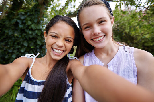 Happy girl, children and portrait with selfie for friendship, bonding or outdoor fun together. Teenagers, smile or kids with picture for photography, capture moment or social media in backyard garden - Powered by Adobe
