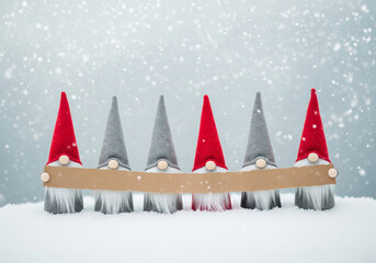 Christmas gnomes standing in a snowy landscape, holding a blank sign for messages