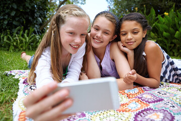 Outdoor, children and smile with selfie for social media, childhood memories or bonding on vacation. Friends, girls and photo in nature with happiness for summer holiday, connection or internet post.