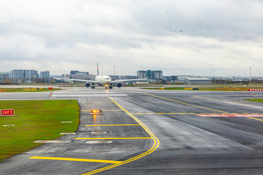 Paris, France - 19.11.2025: A runway with a passenger plane preparing for takeoff and another plane in the air.