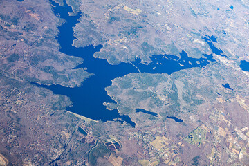 View of the earth with water bodies and land from the height of an airplane.
