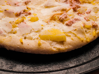 German pizza style dish with ham, potato, cheese and creamy sauce on a metal tray. Popular and tasty dish. Simple dinner.