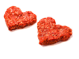 Two fresh beef burgers made in heart shape made for a romantic dinner. Love and passion concept. Premium meat. Top quality product. Creative food. White background.