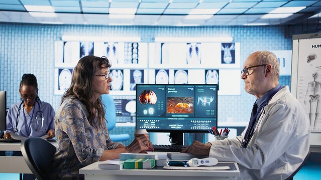 Medical consultation on tumor screening takes place with specialist and elderly patient, medic recommending early detection and lifestyle adjustments for cancer prevention. Camera A.