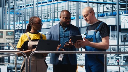 Supervisor overseeing work done by engineers in industry 4.0 solar panels plant to reduce downtime. Photovoltaics smart factory manager tasking workers with fixing damaged IoT sensors, camera A