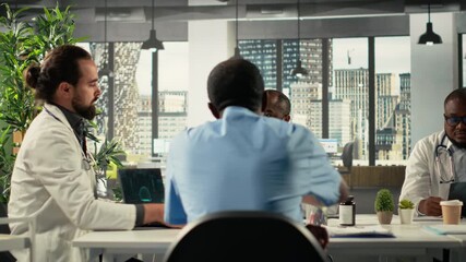 Team of doctors and nurses in meeting discuss treatment strategies and diagnosis plans. Diverse healthcare team collaborates on innovation and patient care solutions. Camera B.