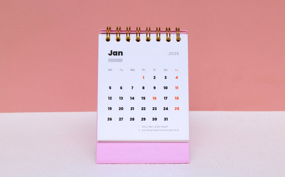 January 2026 on a pink calendar on a desk with a pink background. January 2026 calendar on a desk