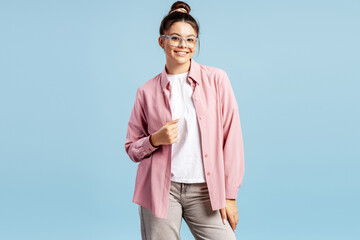Smiling young woman posing with confidence, wearing glasses and a pink shirt