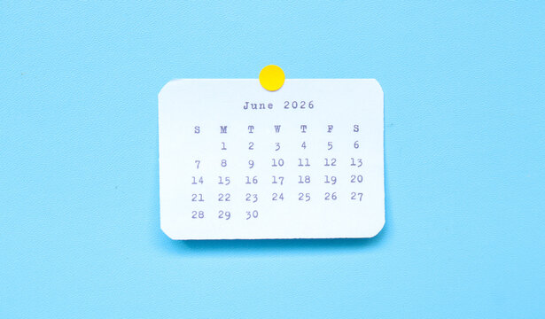 A paper sticker showing June 2026 placed on a blue background. A june 2026 sticker attached to a blue background. Minimal and clean calendar concept.