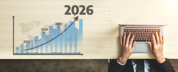A professional business setting showcasing a laptop and a bar graph signifying growth projections for 2026, illustrating future trends and strategic planning. Tessel