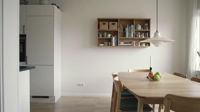 Modern kitchen and dining area with natural light and simple decor.