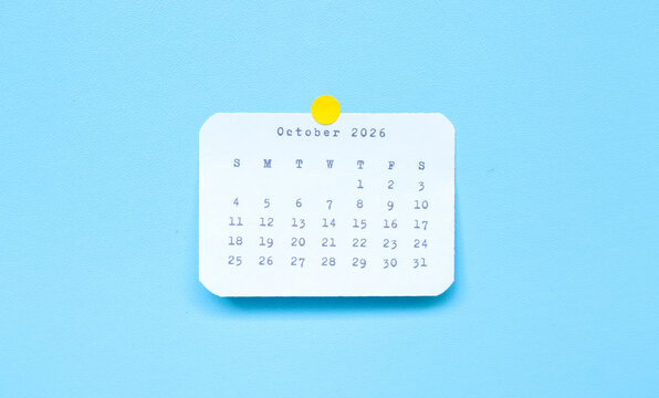 A paper sticker showing October 2026 placed on a blue background. october 2026 sticker attached to a blue background. Minimal and clean calendar concept.