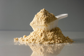 Spoon with protein on colored background.